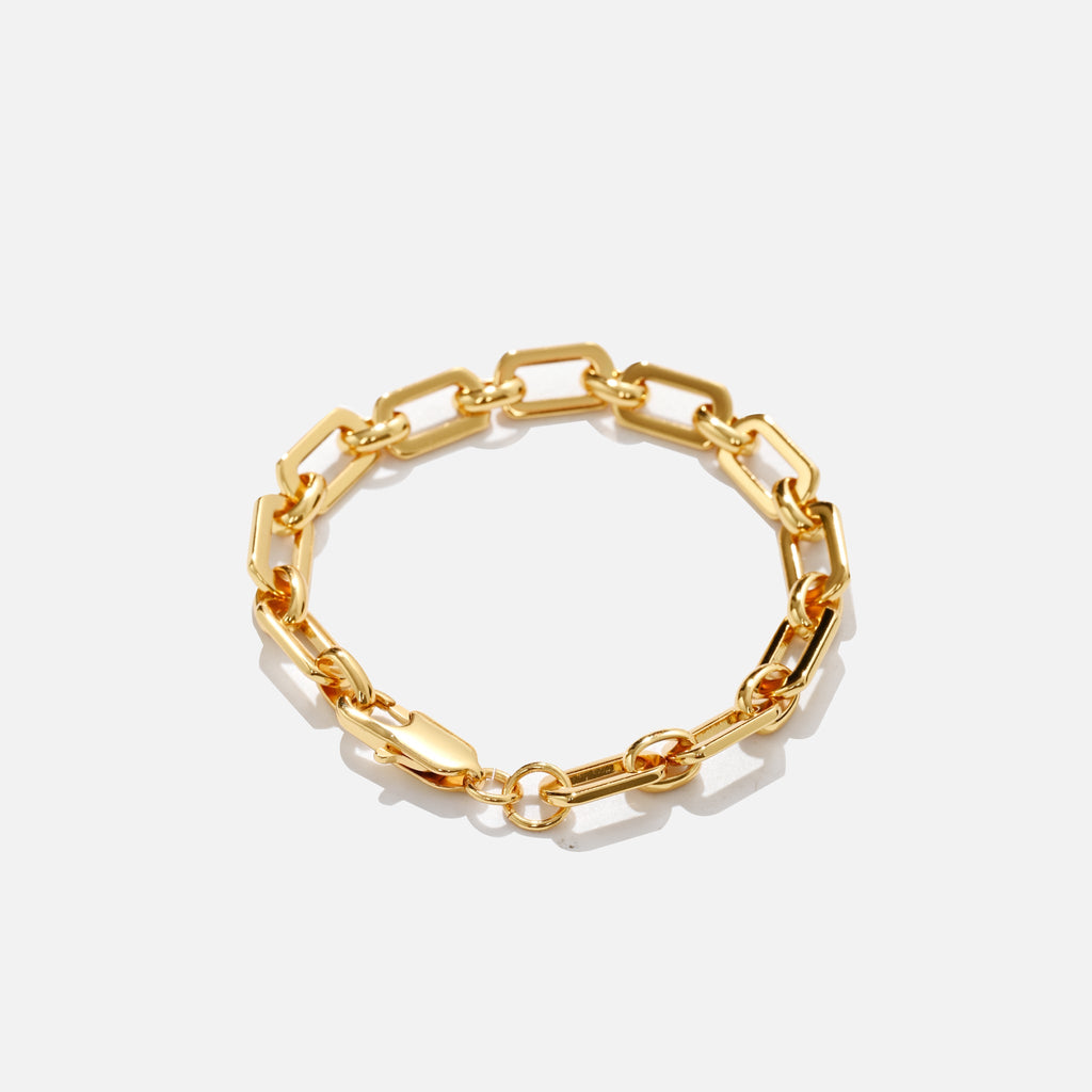 Gold chain bracelet on a light gray background
