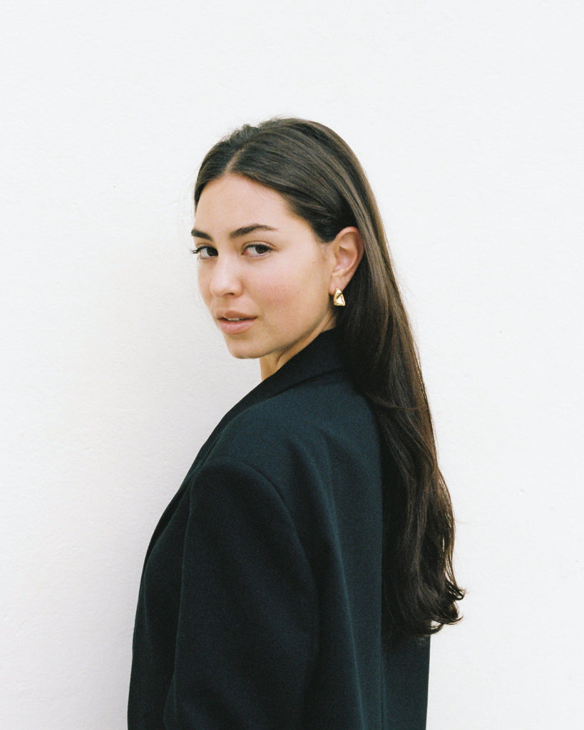 Woman wearing a black coat against a white background