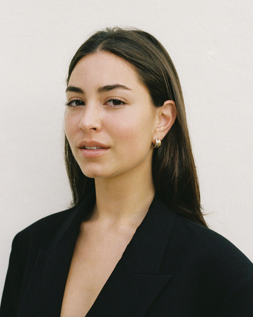 Woman wearing a black blazer against a plain background
